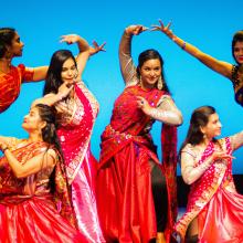 Indian students performing a dance on a stage