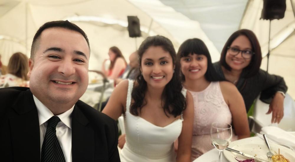 A group poses for a selfie at a wedding.