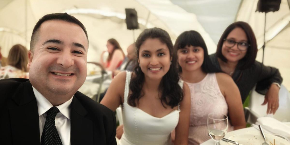 A group poses for a selfie at a wedding.