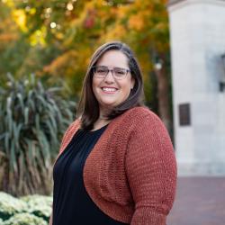 Photo of woman smiling at camera in front of Sample Gates