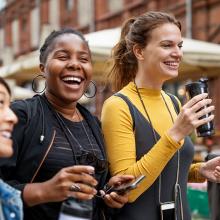 photo of four smiling young women walking