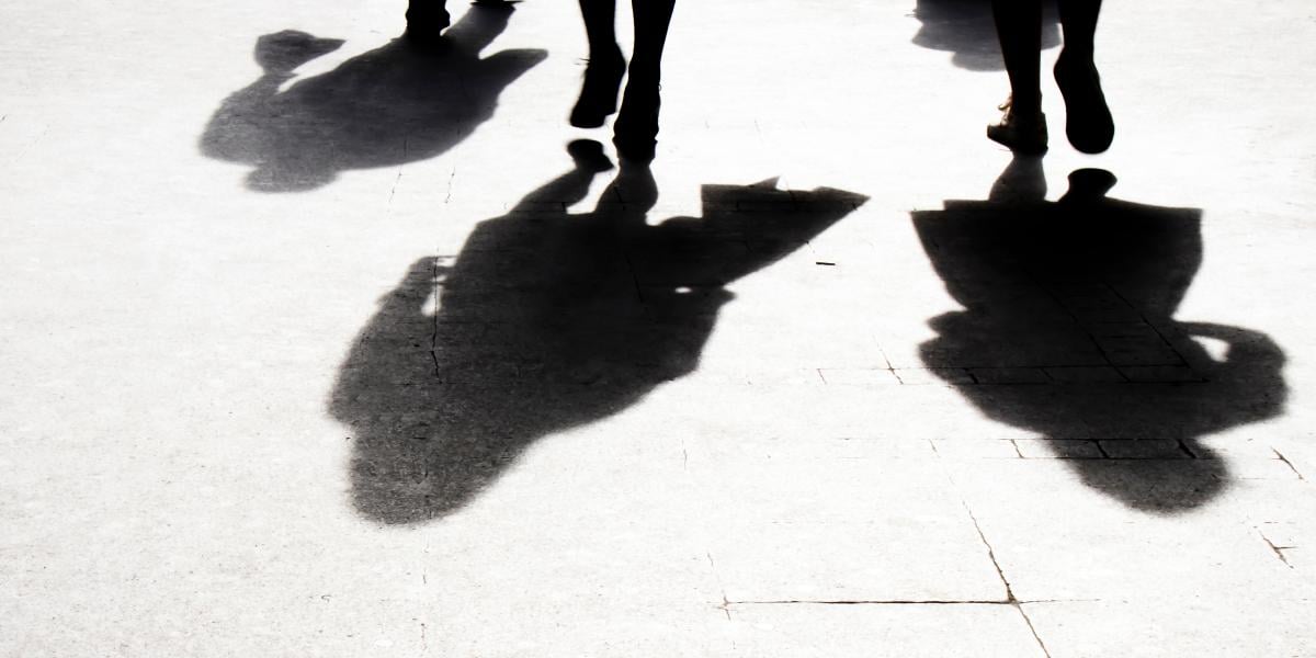 Shadows of three people walking