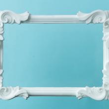 White ornate picture frame on a blue background