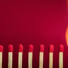 unlit matches in a row with one match that is burned