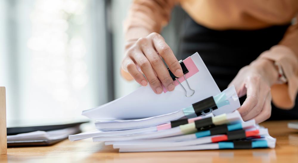 Desk with stack of paper files