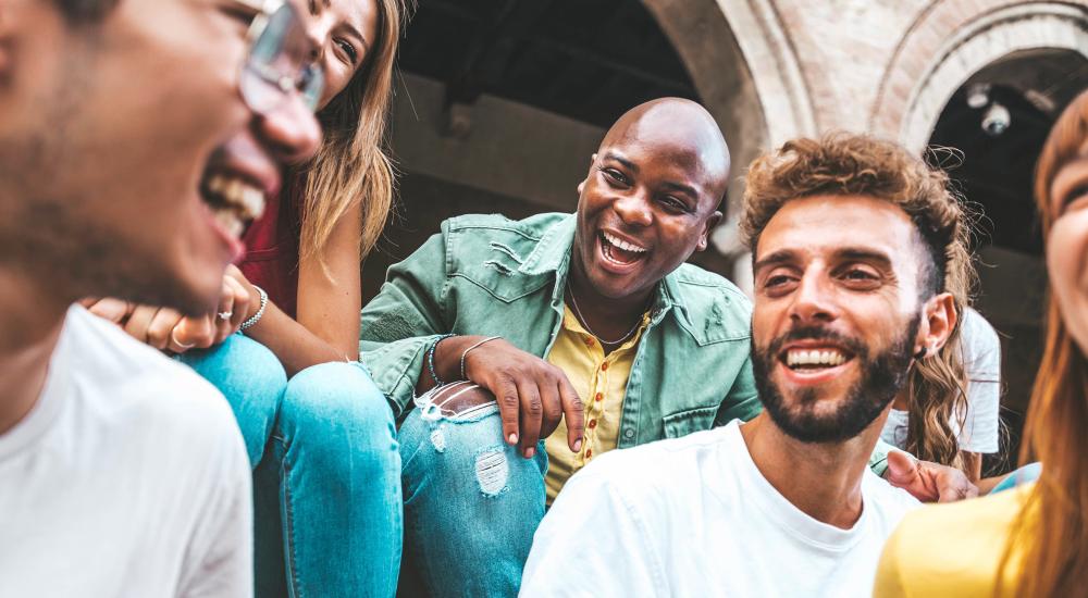 diverse group of young people sitting and laughing together