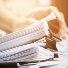Person going through a stack of paperwork